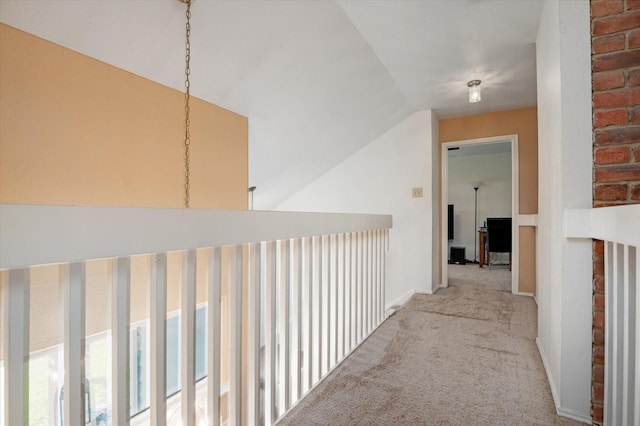 hallway with light colored carpet and vaulted ceiling