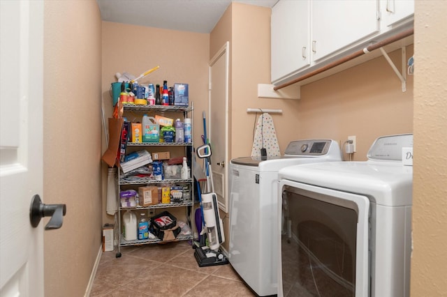 washroom with cabinets, light tile patterned floors, and washer and dryer