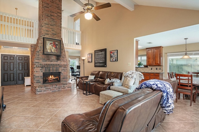 tiled living room with high vaulted ceiling, ceiling fan, a fireplace, beamed ceiling, and a healthy amount of sunlight