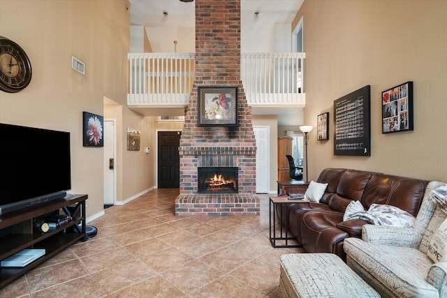 living room featuring tile patterned floors, a high ceiling, and a brick fireplace