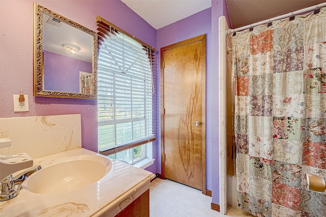 bathroom featuring tile patterned flooring, vanity, and curtained shower