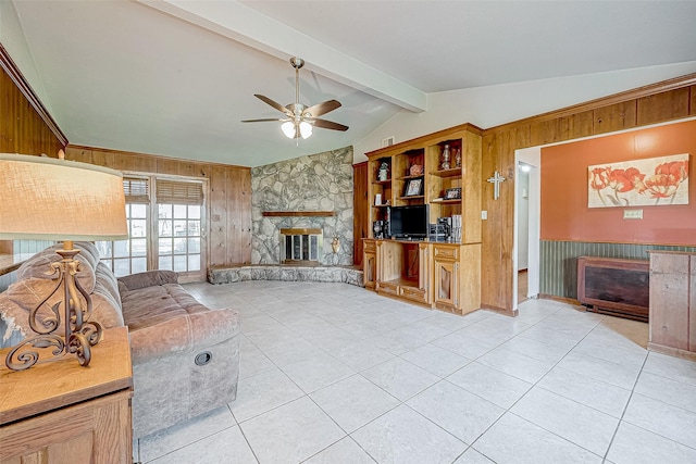 unfurnished living room with ceiling fan, vaulted ceiling with beams, wooden walls, a fireplace, and light tile patterned floors