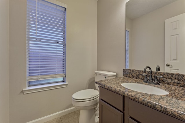 bathroom with tile patterned flooring, vanity, and toilet