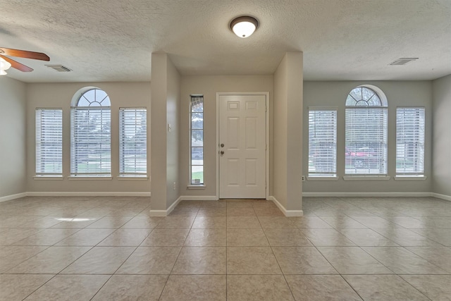 tiled entryway featuring ceiling fan and a textured ceiling