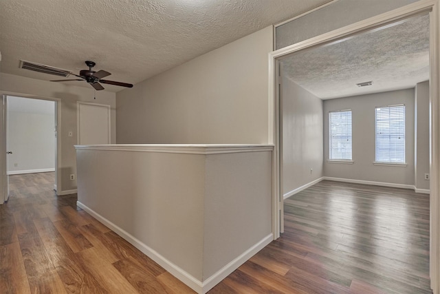 hall with a textured ceiling and hardwood / wood-style flooring