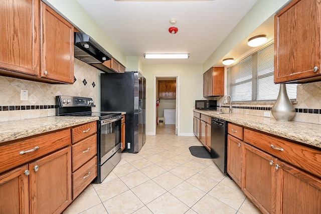 kitchen with sink, light stone counters, extractor fan, light tile patterned floors, and black appliances