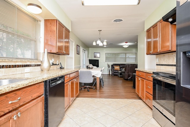 kitchen with black dishwasher, tasteful backsplash, stainless steel gas range oven, pendant lighting, and light tile patterned floors