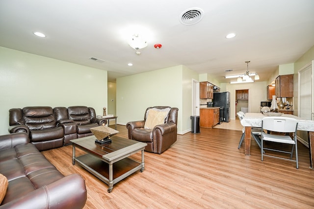 living room featuring light hardwood / wood-style flooring and a notable chandelier