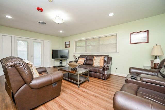 living room featuring french doors and light hardwood / wood-style flooring