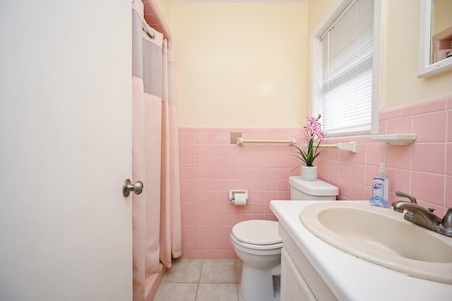 bathroom with tile patterned flooring, vanity, tile walls, and toilet