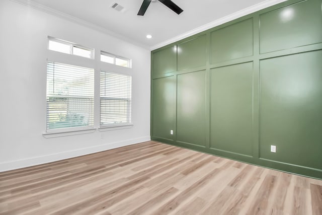 empty room featuring ceiling fan, light wood-type flooring, and ornamental molding