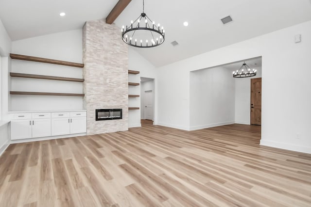 unfurnished living room featuring light wood-type flooring, beam ceiling, high vaulted ceiling, built in features, and a fireplace