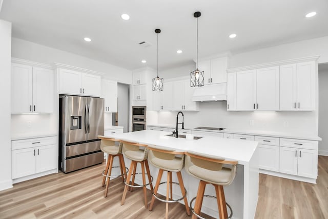 kitchen with appliances with stainless steel finishes, decorative light fixtures, white cabinetry, and sink