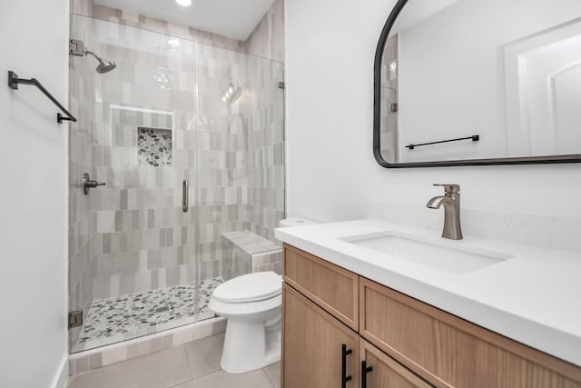 bathroom with tile patterned flooring, vanity, a shower with door, and toilet