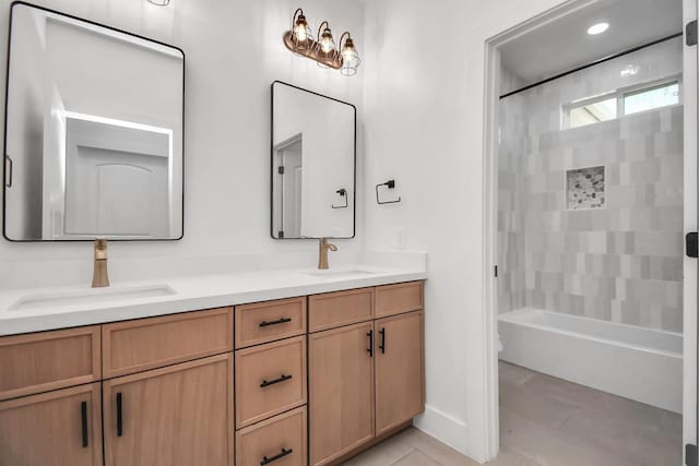 bathroom featuring tile patterned flooring, vanity, and tiled shower / bath