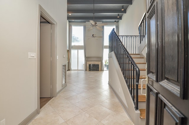 tiled foyer featuring beam ceiling and ceiling fan