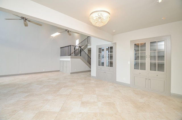 unfurnished living room with ceiling fan with notable chandelier