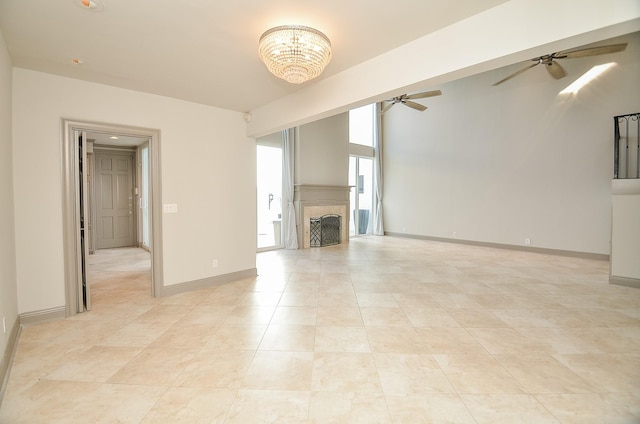 unfurnished living room with ceiling fan with notable chandelier