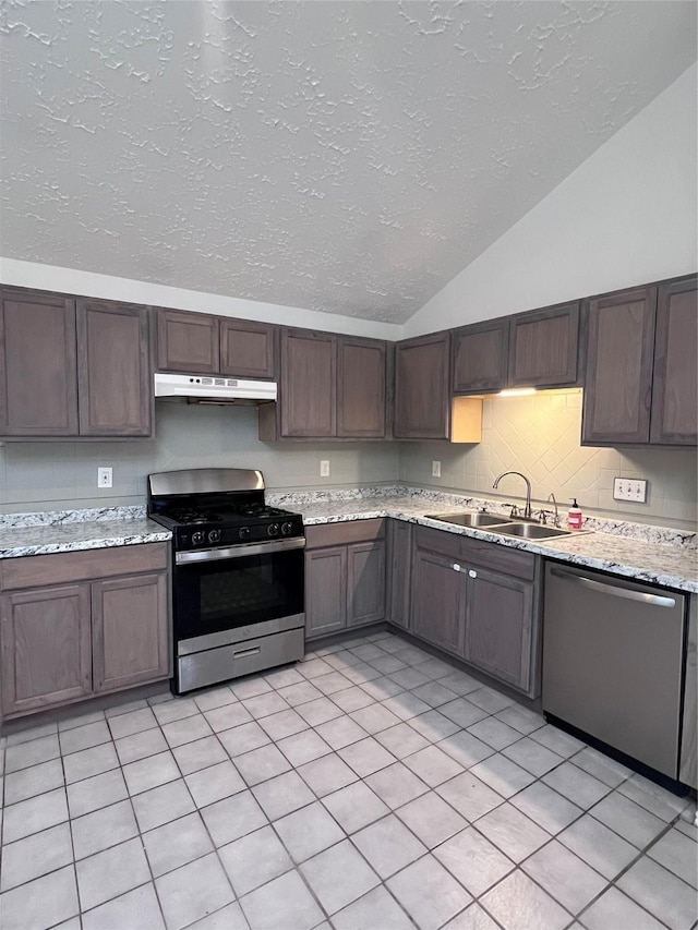 kitchen featuring dark brown cabinetry, light stone countertops, sink, light tile patterned flooring, and appliances with stainless steel finishes