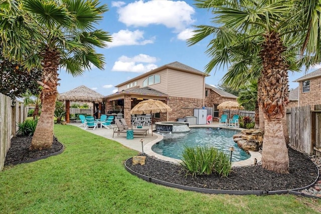 view of swimming pool with a lawn, a patio area, and an in ground hot tub