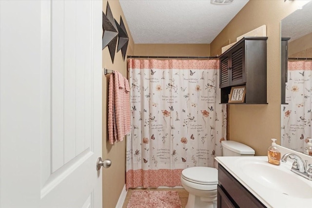 bathroom featuring curtained shower, vanity, a textured ceiling, and toilet