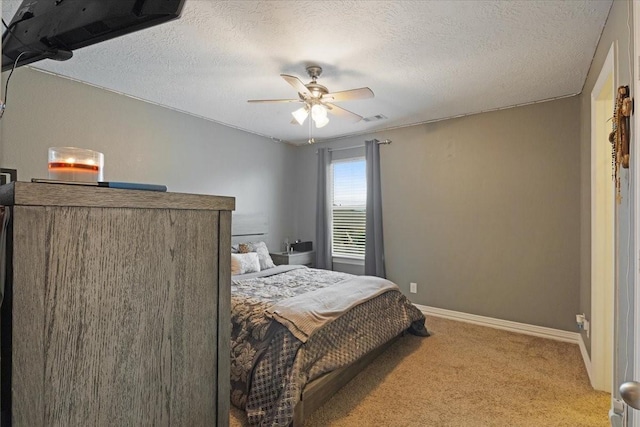 carpeted bedroom with ceiling fan and a textured ceiling