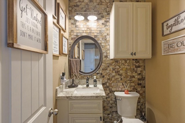 bathroom featuring decorative backsplash, vanity, and toilet