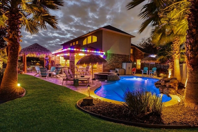 pool at dusk with an in ground hot tub, a gazebo, a patio area, and a lawn