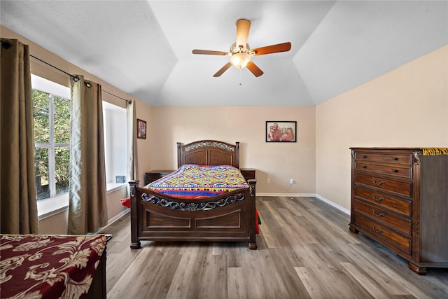 bedroom with wood-type flooring, ceiling fan, and lofted ceiling