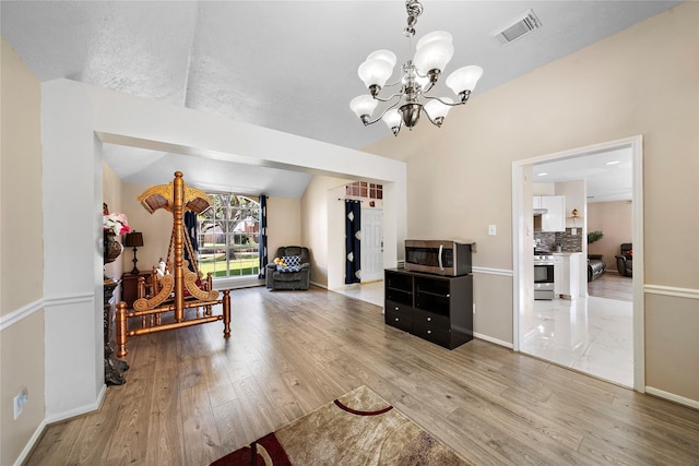 interior space with hardwood / wood-style floors, a chandelier, and vaulted ceiling