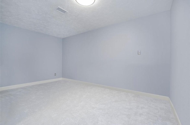 unfurnished room featuring carpet and a textured ceiling