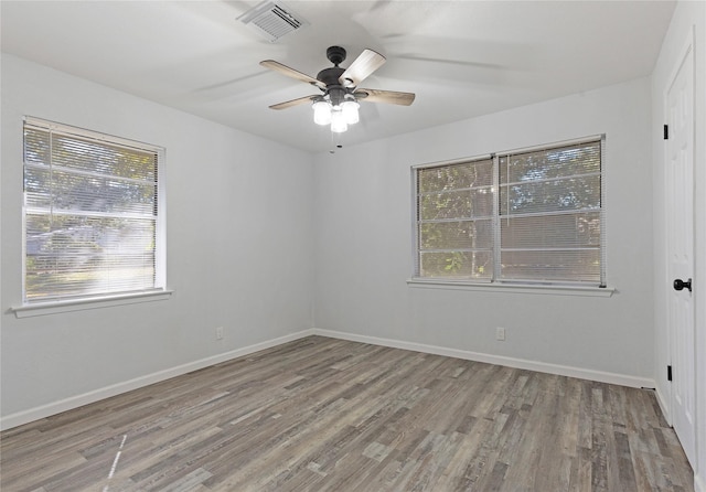 empty room featuring light hardwood / wood-style flooring, ceiling fan, and a healthy amount of sunlight