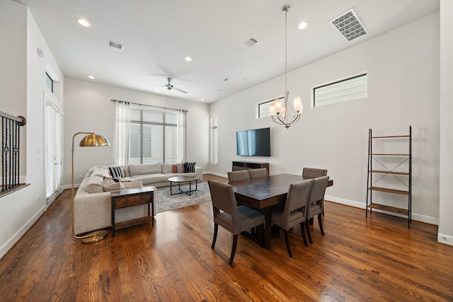 dining space with ceiling fan with notable chandelier and dark hardwood / wood-style floors