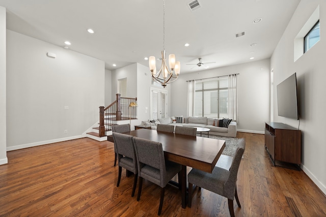 dining area featuring ceiling fan with notable chandelier and dark hardwood / wood-style floors