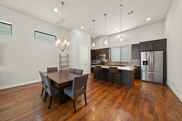 dining area featuring dark hardwood / wood-style floors and a chandelier