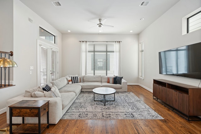 living room featuring ceiling fan and dark wood-type flooring