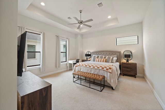 carpeted bedroom featuring a raised ceiling and ceiling fan