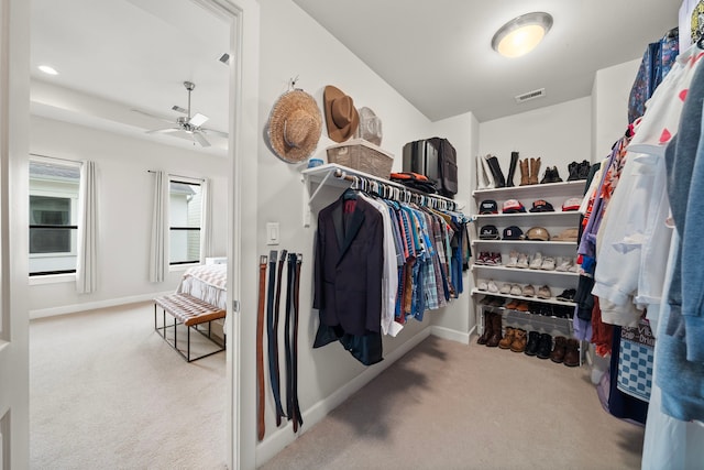 spacious closet with ceiling fan and light colored carpet