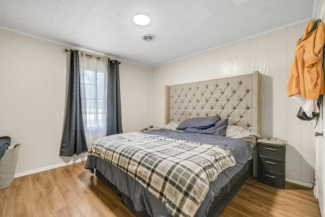 bedroom featuring wood-type flooring and crown molding