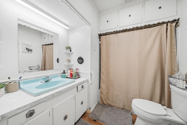 bathroom with hardwood / wood-style flooring, vanity, toilet, and walk in shower