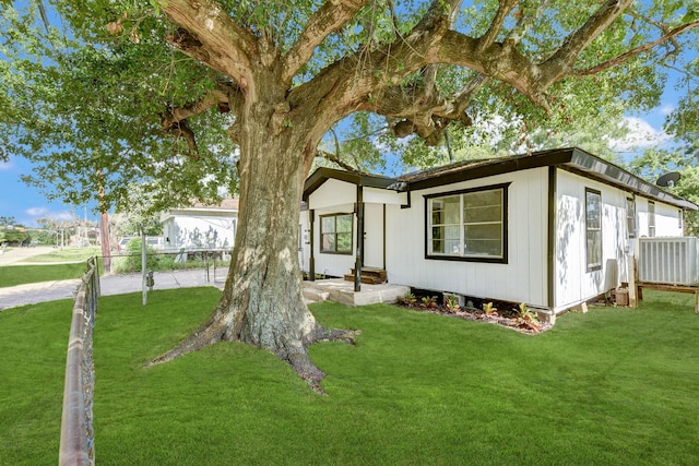 view of front facade with a front yard and central AC