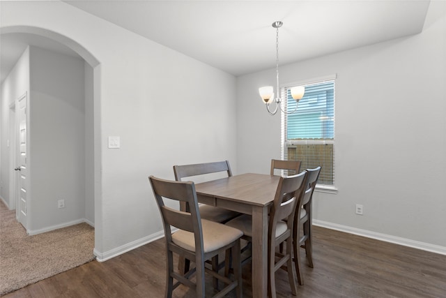 dining room featuring dark hardwood / wood-style floors and an inviting chandelier