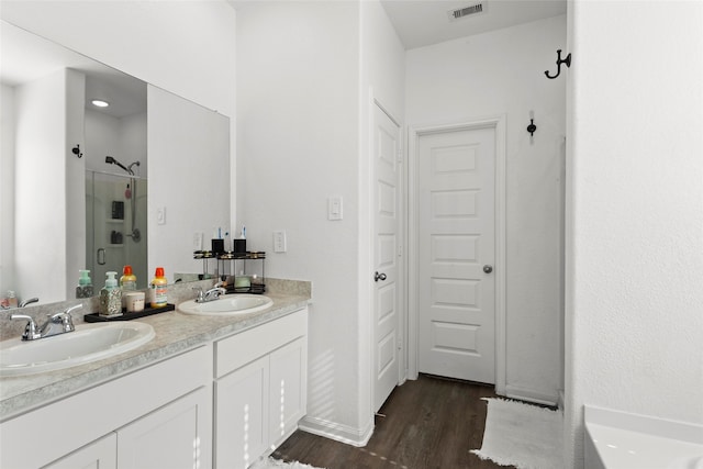 bathroom featuring hardwood / wood-style floors, vanity, and a shower with door