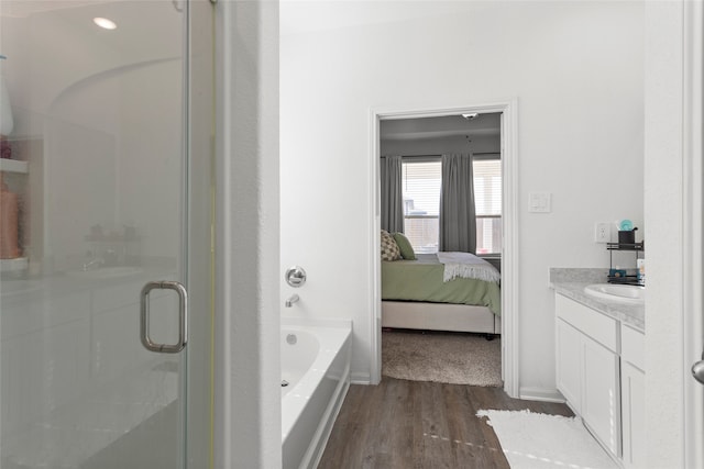 bathroom featuring wood-type flooring, vanity, and separate shower and tub