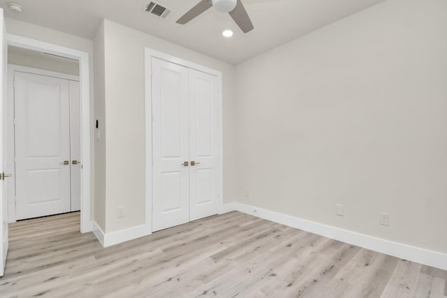 unfurnished bedroom featuring ceiling fan, light wood-type flooring, and a closet