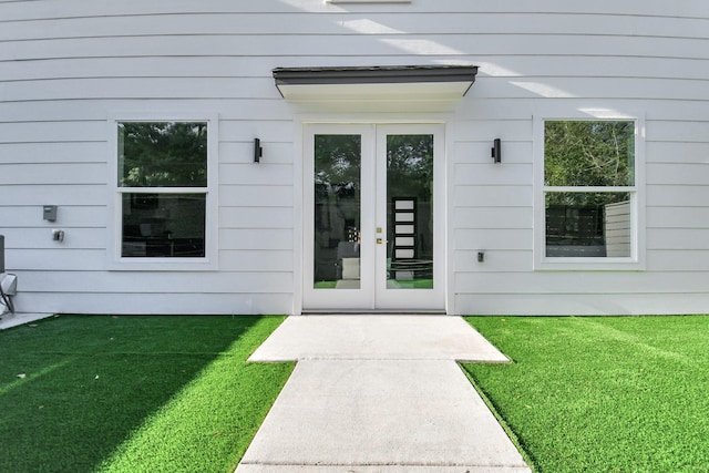 entrance to property featuring a yard and french doors