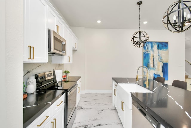 kitchen featuring white cabinetry, sink, stainless steel appliances, a notable chandelier, and decorative light fixtures