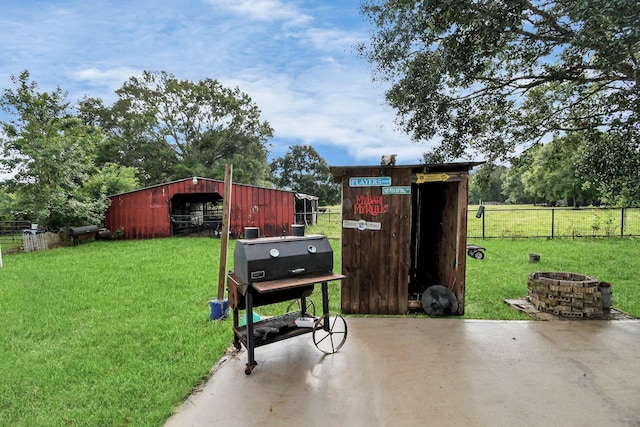 view of yard with an outbuilding, a patio, and an outdoor fire pit