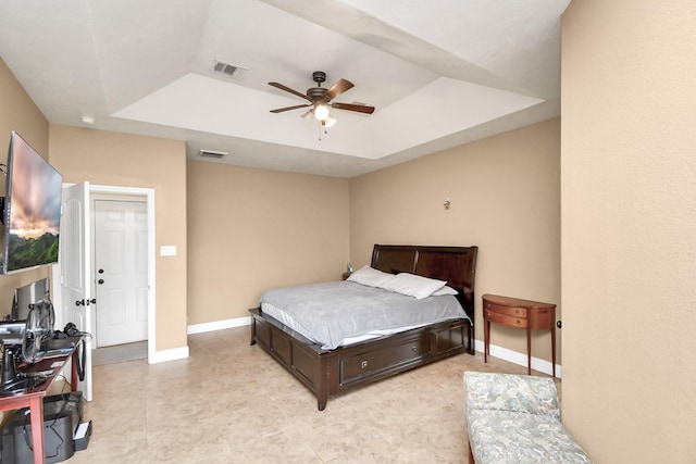 bedroom with a raised ceiling and ceiling fan