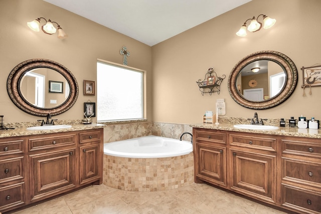 bathroom with tile patterned floors, a relaxing tiled tub, and vanity